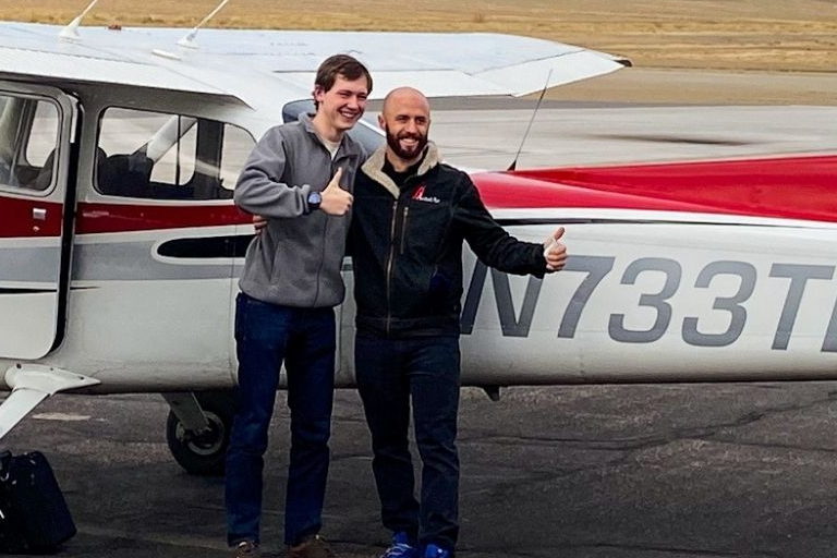 Two people in front of an airplane after completing flight instruction